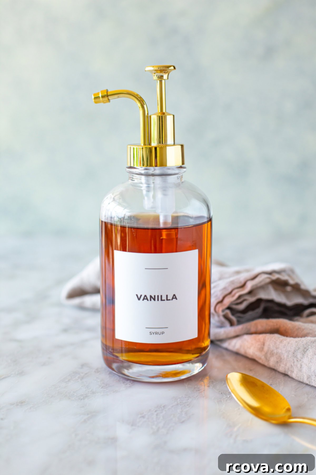 Easy Homemade Vanilla Syrup for Iced Coffee 8 Side shot of vanilla syrup in a pump dispenser bottle, ready for use in coffee or other drinks.