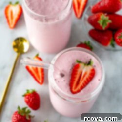 High-Protein Strawberry Power Smoothie 9 overhead shot of high protein strawberry smooth in 2 clear glasses and some strawberries around them 1