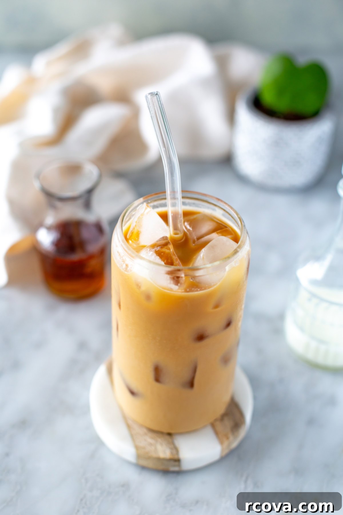 Instant Iced Vanilla Latte 2 Overhead shot of an iced vanilla latte in a clear glass with ice and a straw.
