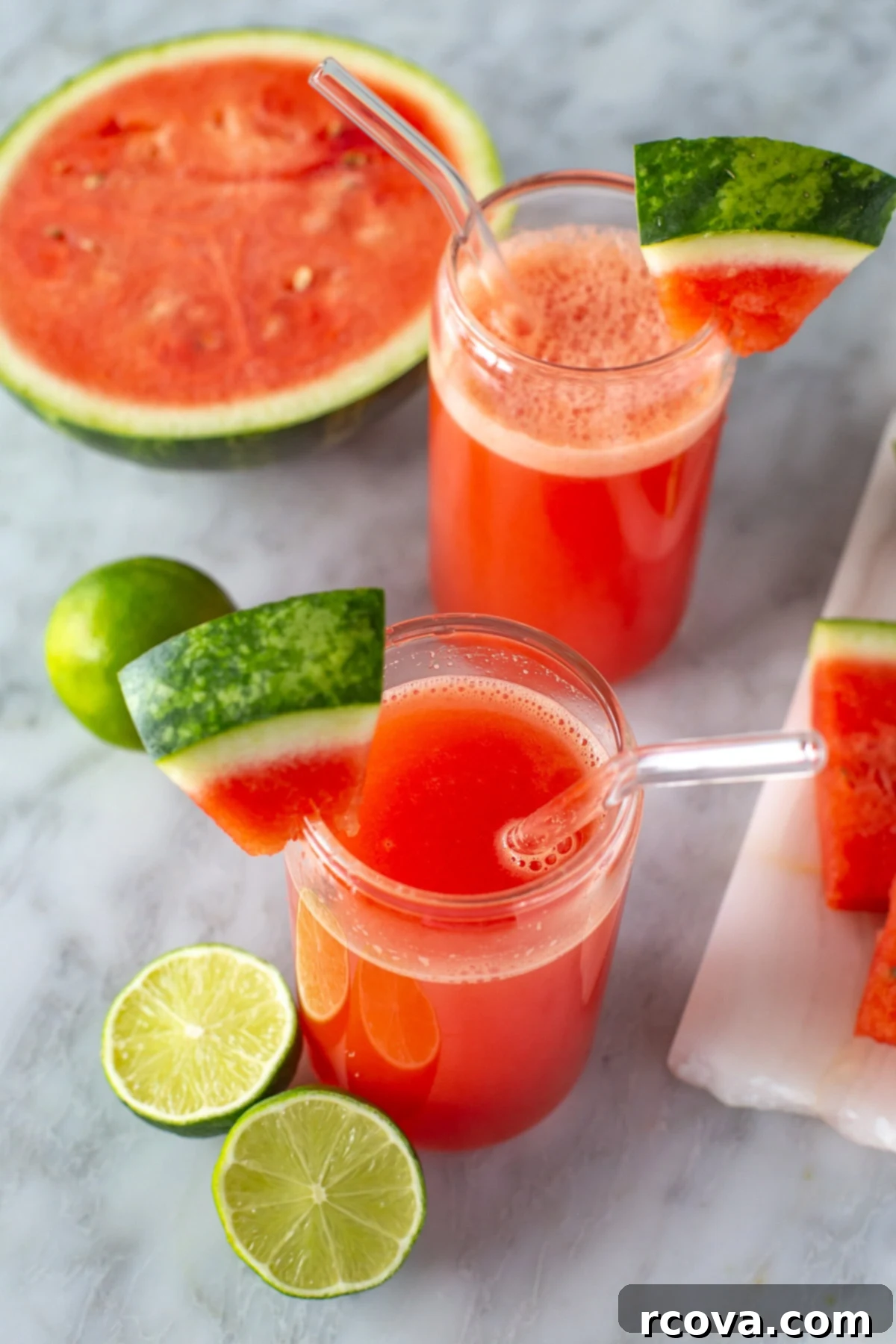 Ruby Red Watermelon Refresher 6 Overhead shot of two glasses of watermelon juice with garnishes and fruit, ready to drink.