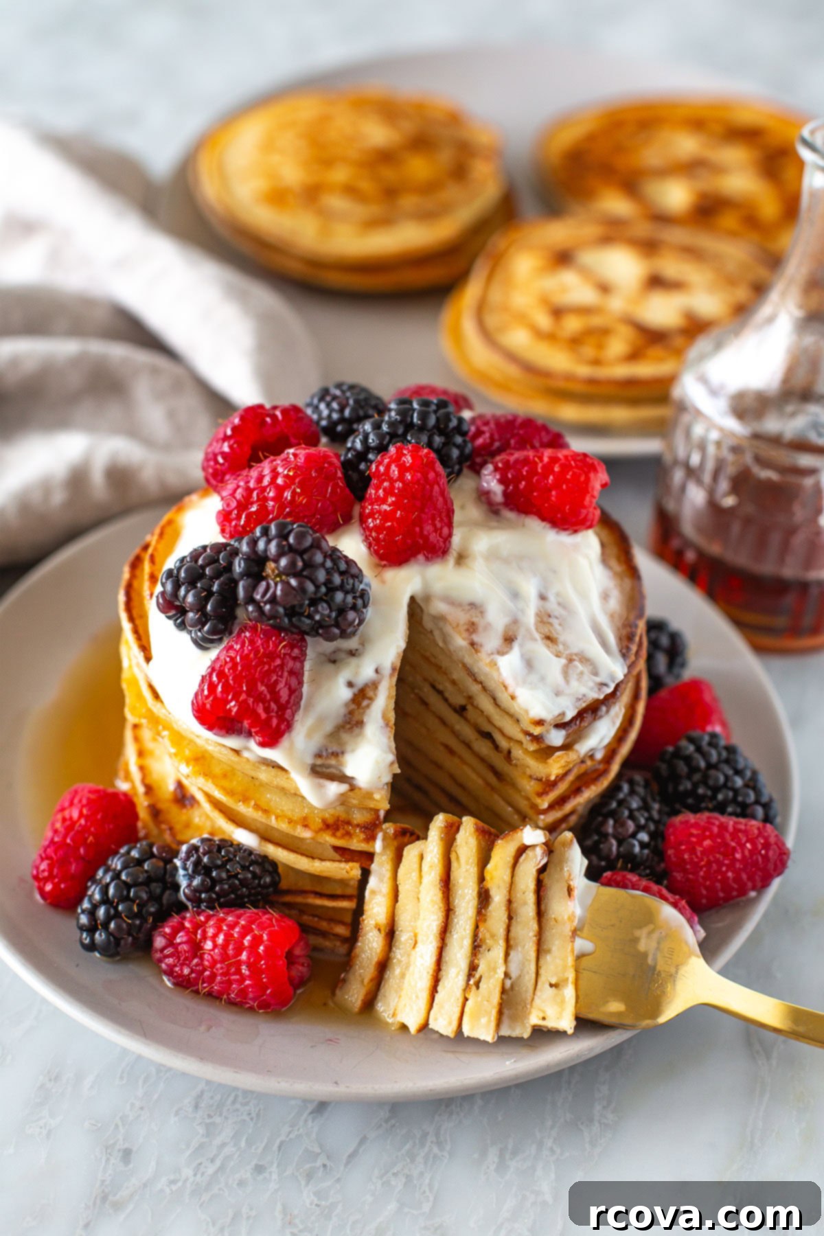Protein-Packed Greek Yogurt Pancakes 7 Side shot of a stack of Greek yogurt pancakes with berries and yogurt.