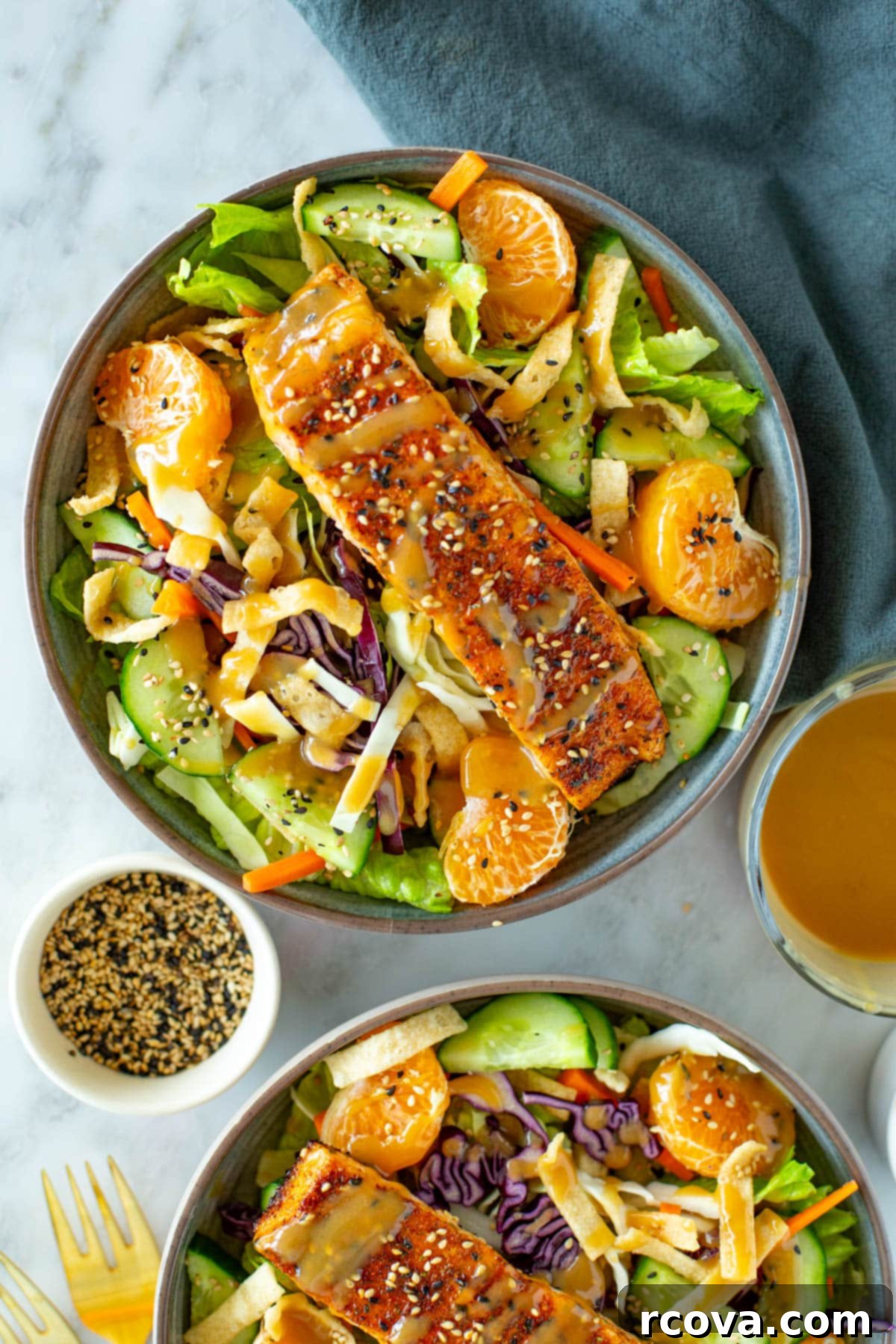 Satisfying Protein Bowls: 20+ Salads to Fuel and Fill 22 A close-up of a bowl of salad with a salmon filet on top.