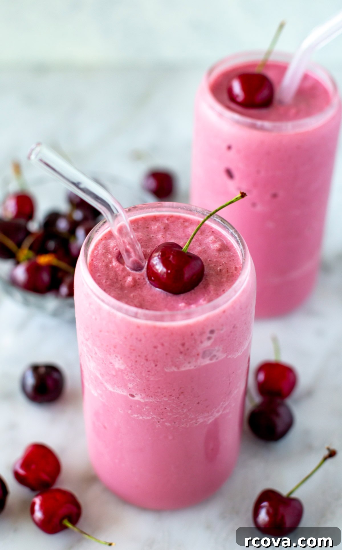 Blissful Cherry Smoothie 2 A refreshing cherry smoothie with a fresh cherry garnish and a straw, ready to be enjoyed.
