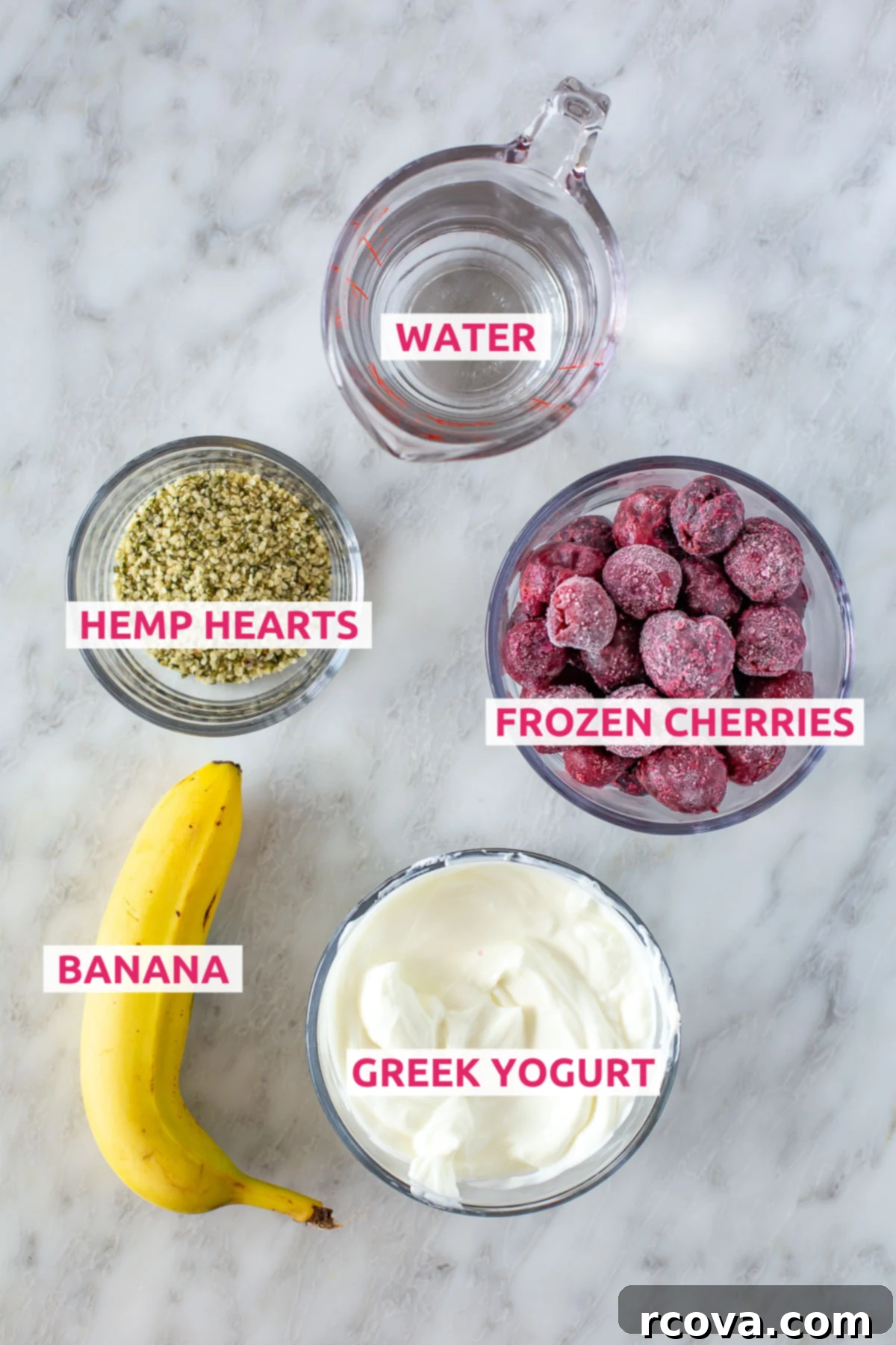 Blissful Cherry Smoothie 4 Overhead shot of all the essential Easy Cherry Smoothie ingredients laid out: water, hemp hearts, frozen cherries, ripe banana, and plain Greek yogurt, all labeled clearly.