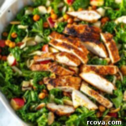 Ultimate Kale Crunch Salad 11 Overhead shot of a bowl of kale crunch salad with sliced chicken and dressing on the side.