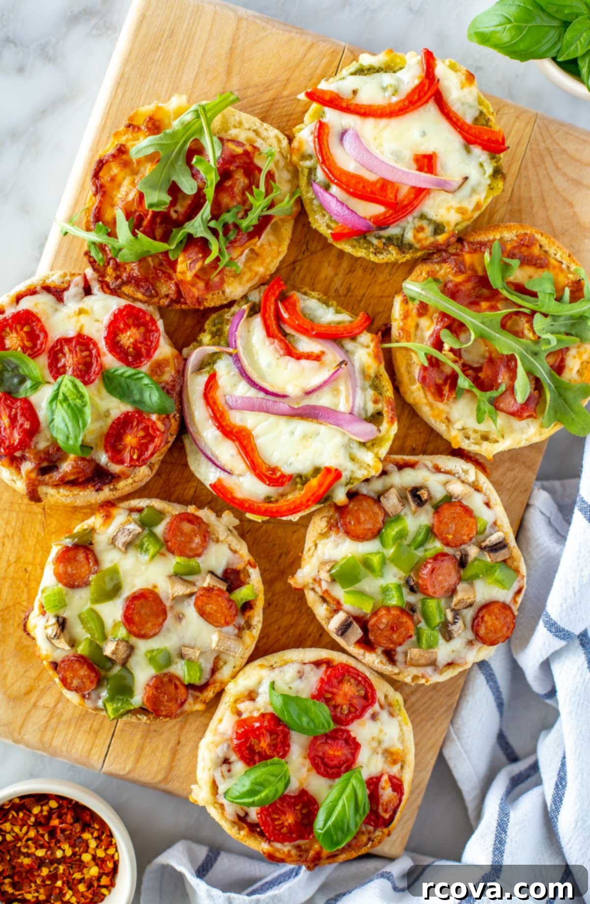 Whip Up Simple Mini Pizzas at Home 8 A close-up of english muffin pizzas on a butcher block.