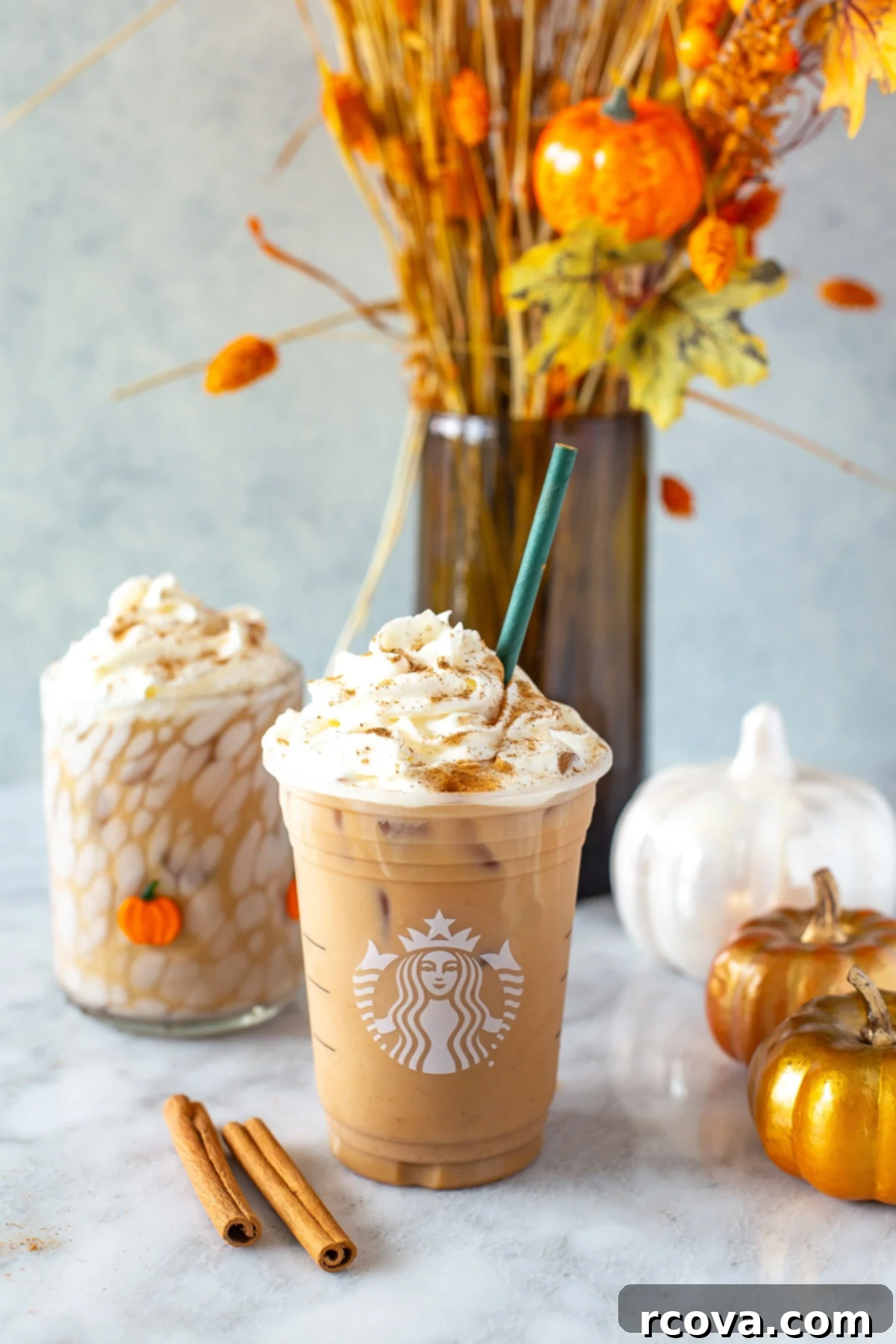 Chilled Autumn Spiced Dream 2 Side shot of a homemade Iced Pumpkin Spice Latte in a Starbucks-style cup, topped with generous whipped cream and a sprinkle of cinnamon, against a cozy fall backdrop.