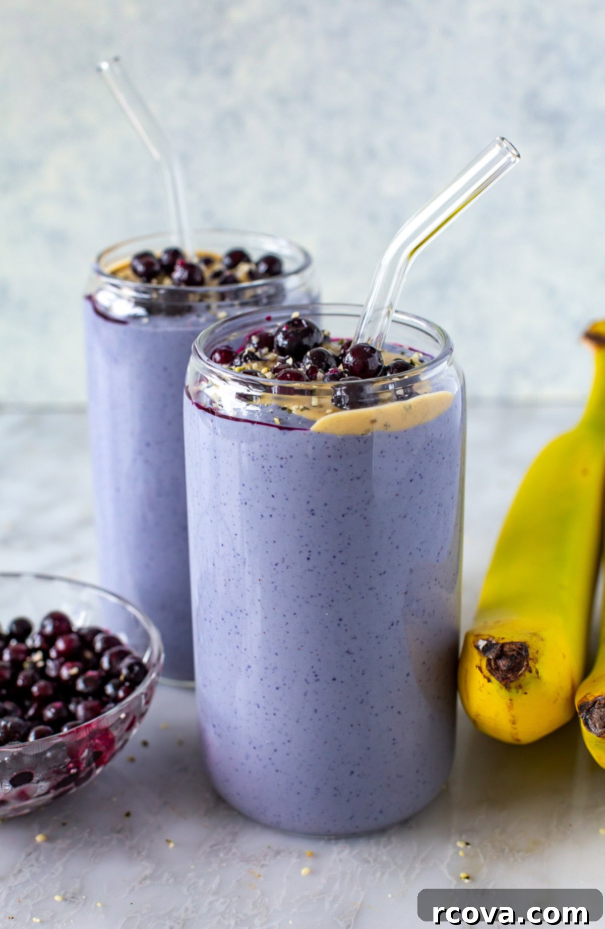 Blueberry Tofu Power Smoothie 7 Side shot of two purple tofu smoothies topped with blueberries and peanut butter.