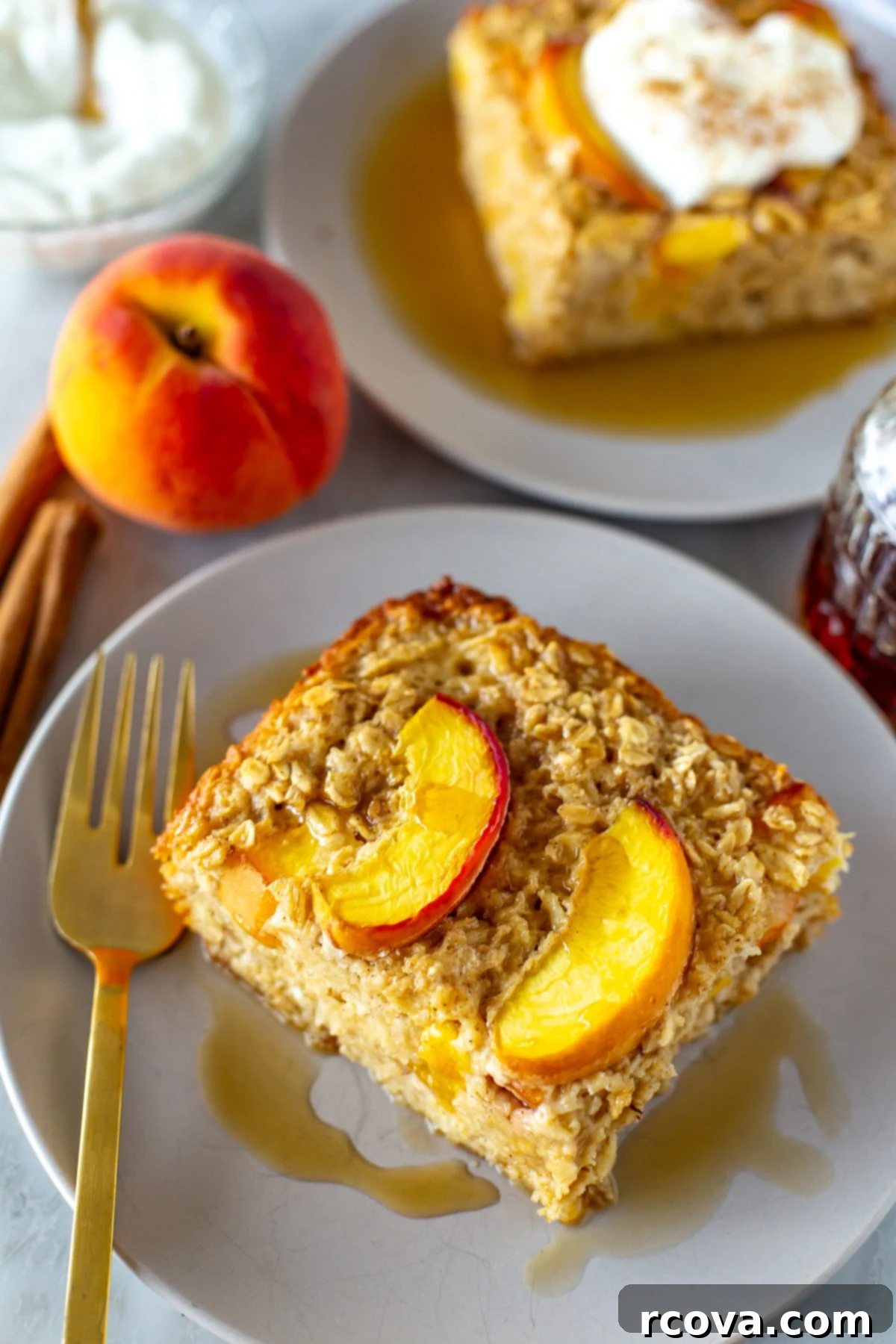 Protein-Packed Peachy Baked Oats 9 Side shot of a perfectly sliced portion of baked peach oatmeal on a white plate, showcasing its layers.
