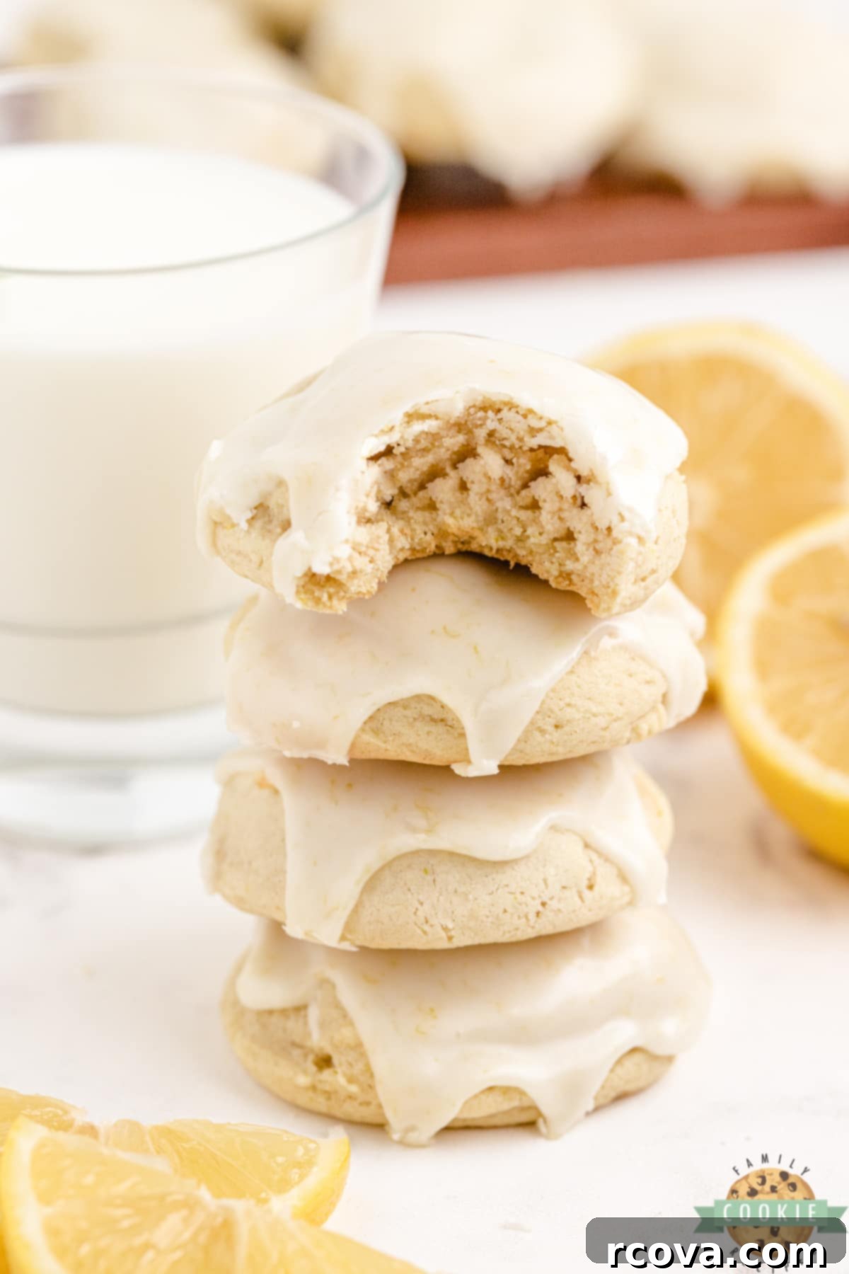 Sunshine Lemon Cheesecake Cookies 3 Close-up shot of thick and soft lemon cream cheese cookies topped with bright lemon icing, stacked on a wire rack