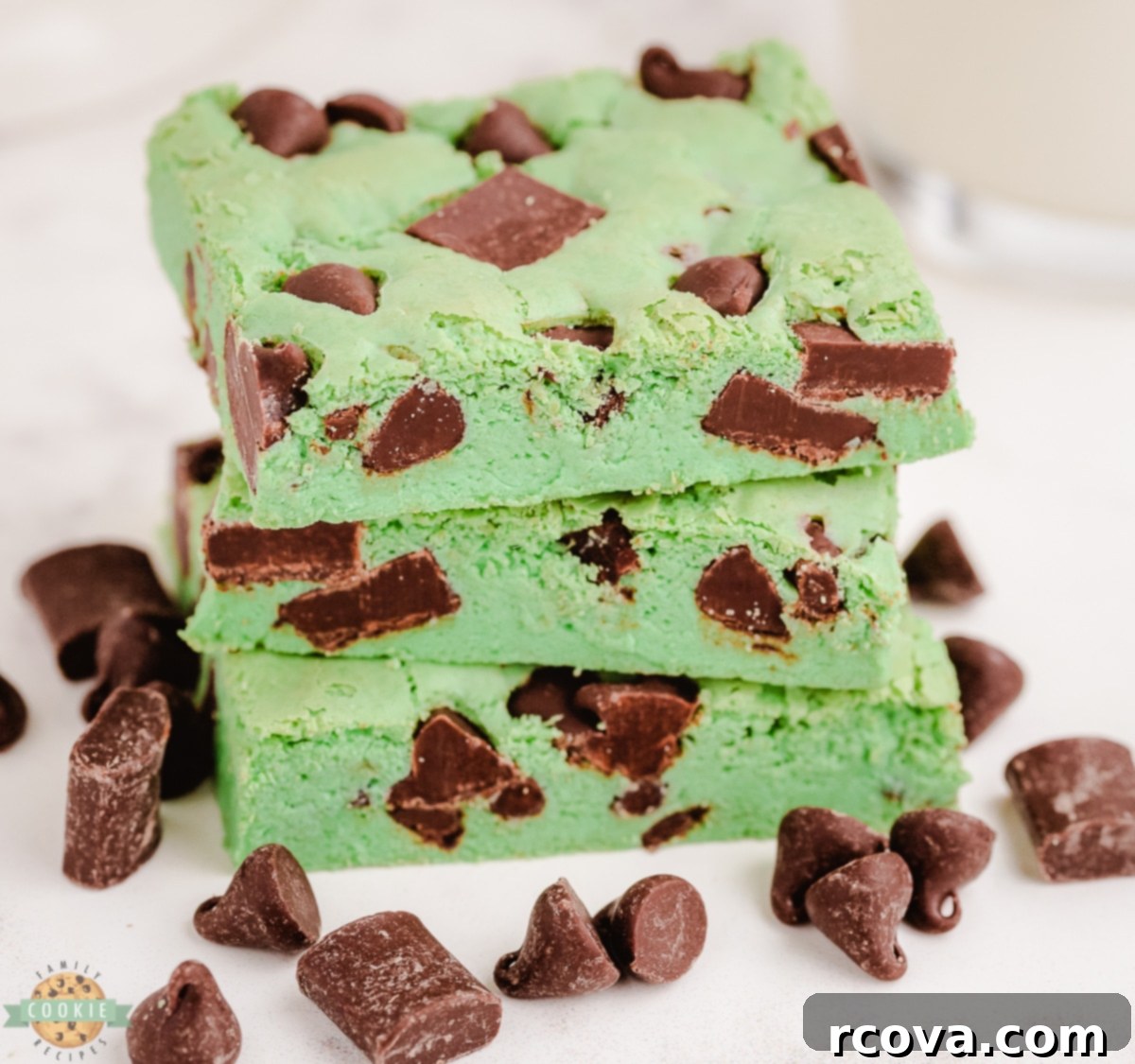 Refreshing Mint Chocolate Chip Cookie Bars 2 Mint Chocolate Chip Cookie Bars on a white plate, showcasing their vibrant green color and chocolate chips.