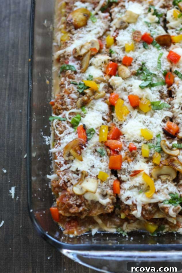 The Ultimate Online Lasagna 7 A generous serving of classic homemade lasagna on a white plate, garnished with basil.