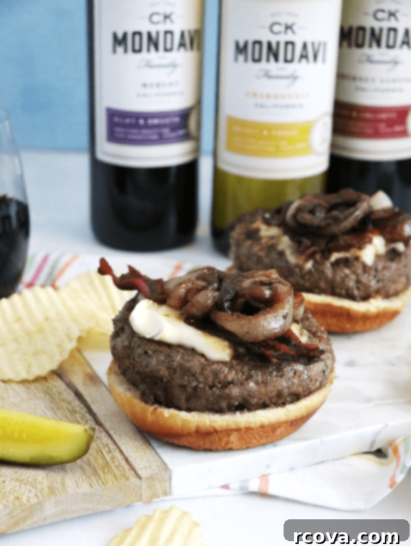 Bacon Brie Burger with Merlot-Caramelized Onions 5 Hand holding a gourmet Bacon Brie Burger with Merlot Onions