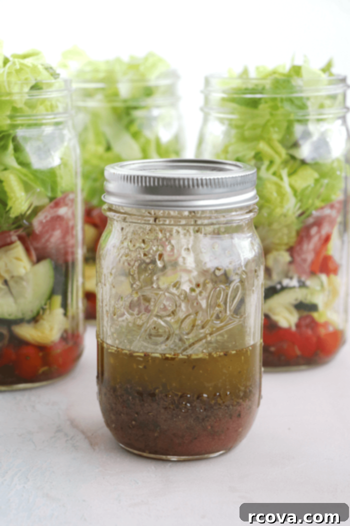 Mason Jar Antipasto: Italian Flavor On-the-Go 3 Close-up of mason jar filled with antipasto salad ingredients, showing the vibrant layers before adding lettuce.