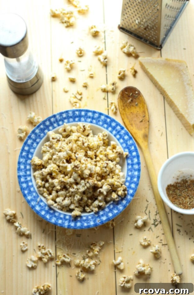 Simple Garlic Parmesan Popcorn 2 Easy Spicy Garlic Parmesan Popcorn: all you need is popping corn, olive oil and a special spice blend for a tasty, low-calorie treat! A close-up shot of perfectly popped popcorn generously coated with a vibrant red spice mix and freshly grated parmesan cheese, ready to be enjoyed.