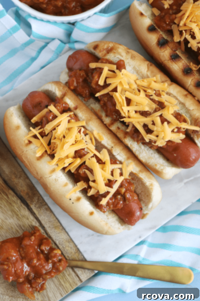 Classic Chili Cheese Dogs 2 Delicious homemade chili cheese dogs on a grill with fresh cheddar