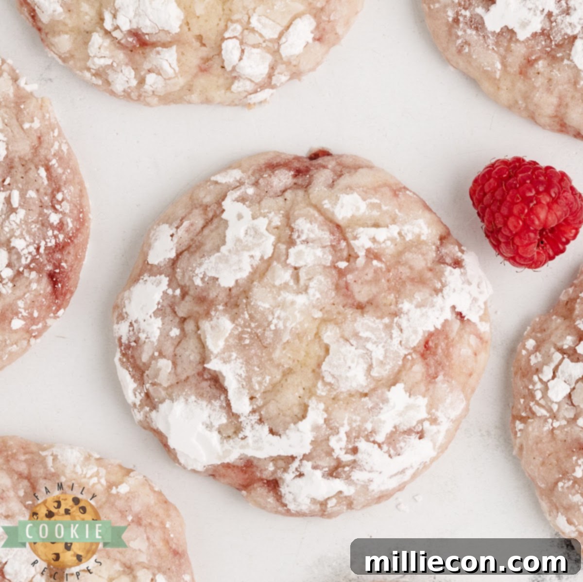 Lemon raspberry crinkle cookies dusted with powdered sugar, showcasing their crackled tops and vibrant colors.