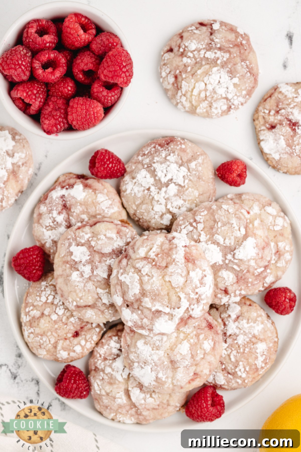 Close-up of Lemon Raspberry Crinkle Cookies, highlighting the crackly powdered sugar tops and raspberry swirls.